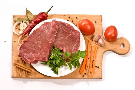 raw meat and vegetables on the wood board