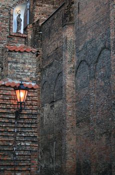 An old church wall with Christ's figurine and a lantern