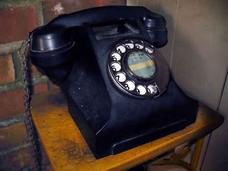Old Black Telephone mounted on wooden shelf
