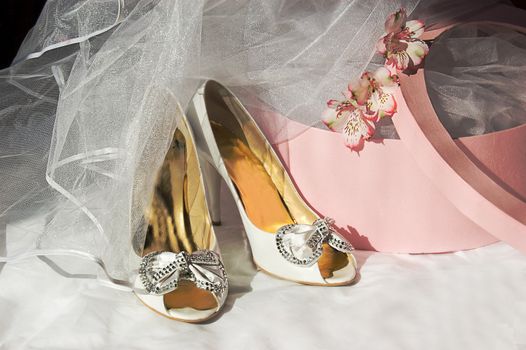 Wedding shoes, veil and box over dark background