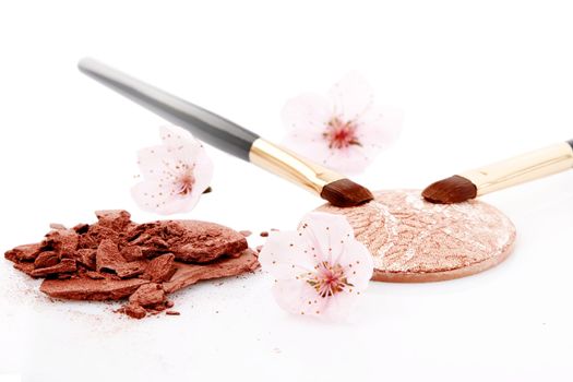brown powder for makeup, flowers and two brush on white background