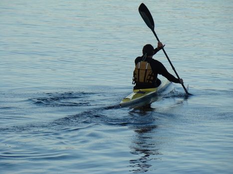 man kayaking on calm lake