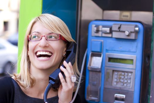 Woman talking on the phone in a retro phone boot