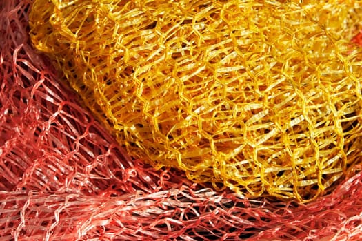 Twisted yellow and red plastic technology mesh  in bright sunlight