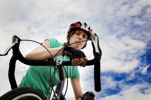 Young woman wearing helmet leaning on a bicycle