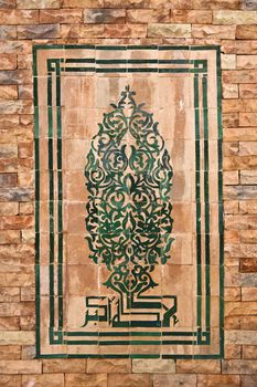 Traditional Arabic mosaic on the brick wall.