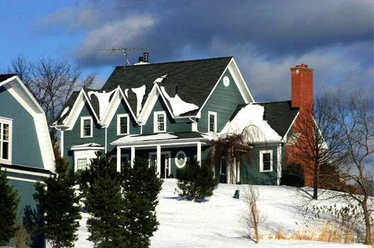 View of greenish cottage covered with snow