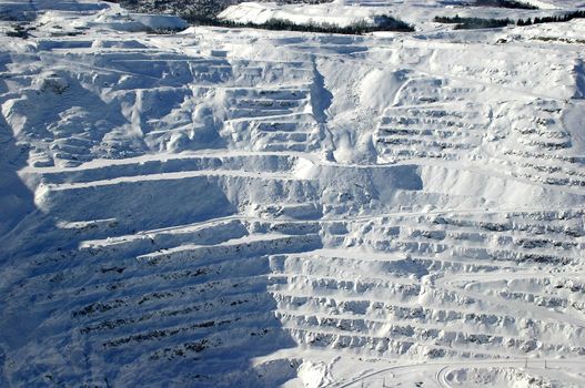 View of snow covered mining steps in open pit