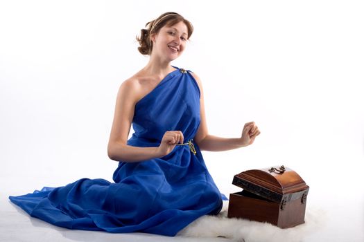 Lady in blue antique dress opening box on white background
