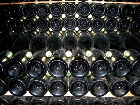 Wine bottles stacked for fermentation in cellar