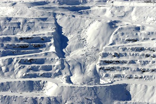 View of avalanche on snow covered mining steps in open pit