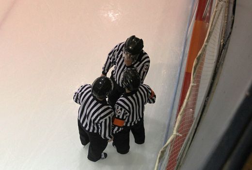 Referees consulting a call in a hockey game