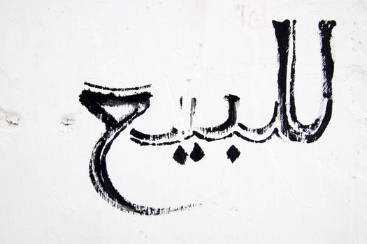 Graffity on the white wall written in arabic