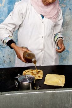 Woman baking delicious moroccan pancakes popular for traditional braeakfasts.