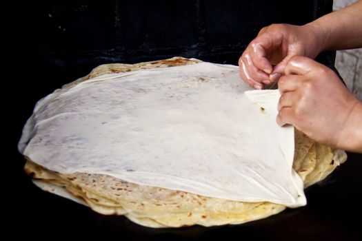 Woman baking delicious moroccan pancakes popular for traditional braeakfasts.