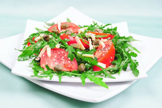 Tomato salad with arugula leaves with cheese and sesame seeds