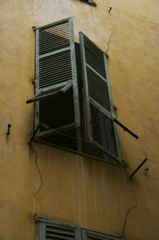 Window with green shutters in the old house