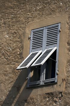 Window in the old rugged house with the gray shutters