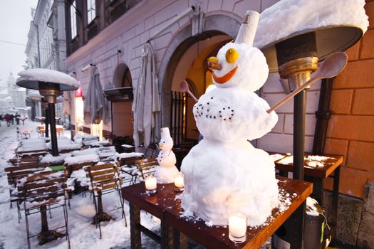 Snowman infront of the bar in Ljubljana's city sentre inviting people in.