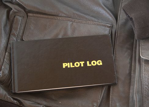 A Pilots log sits on top of a leather A4 aviator jacket