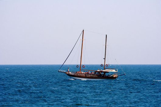 A large catamaran with people floating in the turquoise sea