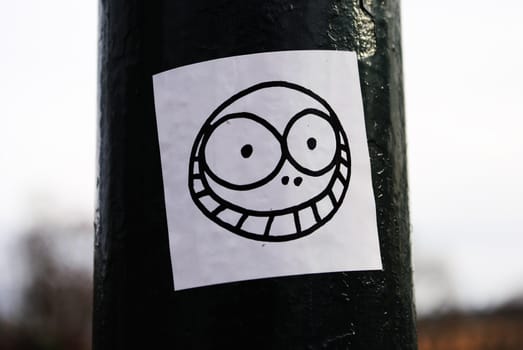 A smiley face street art sticker.