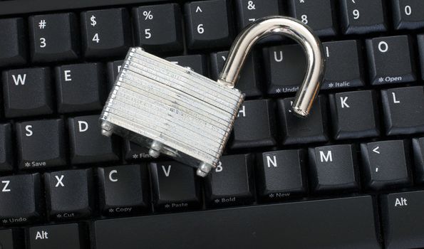 Unlocked padlock on keyboard representing an information security breach