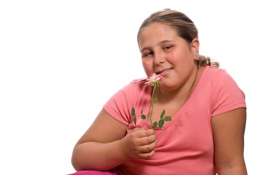 A young girl smelling a fresh rose isolated against a white background