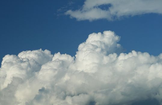 Blue sky with white massive cumulonimbus clouds
