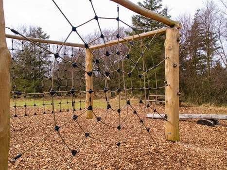 Jungle gym exercise equipment made of wood and ropes in a playground