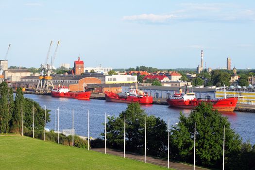 Industrial landscape with two big cranes on the dock and moored ships
