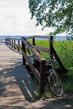 Bikes standing in the front of the wooden pier at the lakeside
