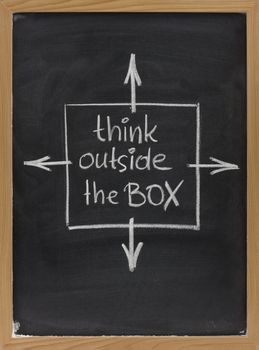 think outside the box - concept of different or unconventional thinking sketched with white chalk on a blackboard with eraser smudges