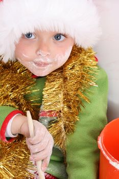 Toddler wearing a christmas hat, baking christmas cookies