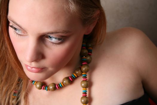 Beautiful female model with blue eyes and a string beads