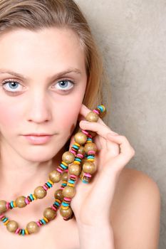 Beautiful female model with blue eyes and a string beads