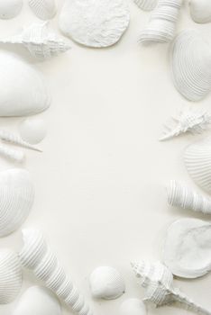 White seashells presented on a white sheet of watercolor textured paper offering a framing format with space for a text