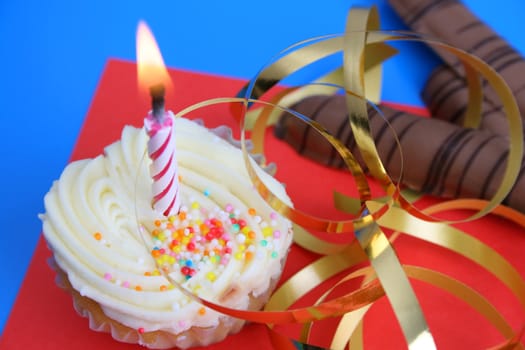 Birthday cake with golden ribbon and a candle