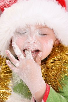 Toddler wearing a christmas hat, baking christmas cookies