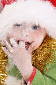 Toddler wearing a christmas hat, baking christmas cookies