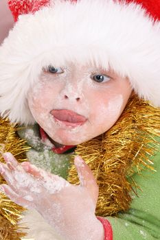 Toddler wearing a christmas hat, baking christmas cookies