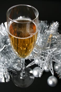 Glass of sparkling wine against silver decorations
