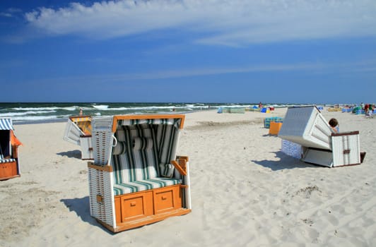 Wicker roofed beach chairs standing at the beach
