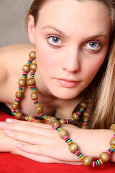 Beautiful female model with blue eyes and a string beads