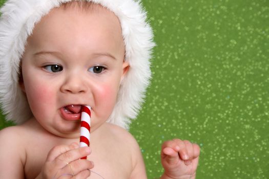 Christmas Baby playing with decorations on a green background