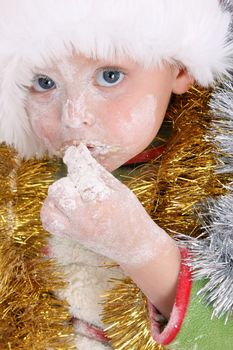 Toddler wearing a christmas hat, baking christmas cookies