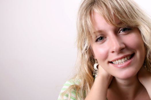 Blond Female model on a white background wearing a green top