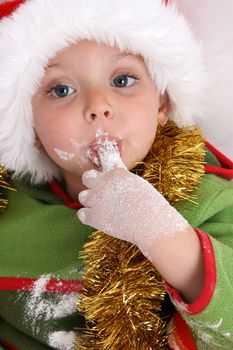 Toddler wearing a christmas hat, baking christmas cookies
