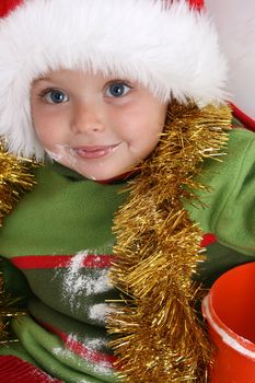 Toddler wearing a christmas hat, baking christmas cookies