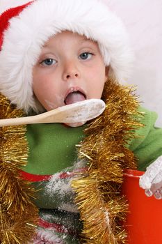 Toddler wearing a christmas hat, baking christmas cookies